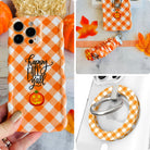 Happy Fall Y'all iPhone Matching Set: hand-held orange gingham MagSafe case with jack-o'-lantern, matching scrunchie wrist strap, and MagSafe grip ring