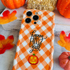 Happy Fall Y'all Wavy Luxe MagSafe iPhone case in orange-and-white gingham with a jack-o'-lantern accent, styled with fall decor