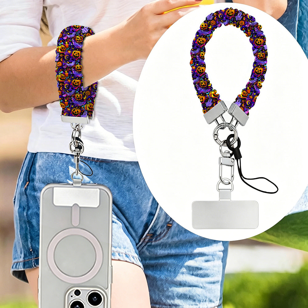 Jack-O-Lantern Jive scrunchie phone wrist strap worn on the wrist and clipped at the hip, with a close-up of the purple neon pumpkin print