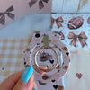 Game Day Darling Hold It Fancy MagSafe grip ring with a cream coquette print of footballs, leopard pumpkins, bows and hearts from Fancy Bands
