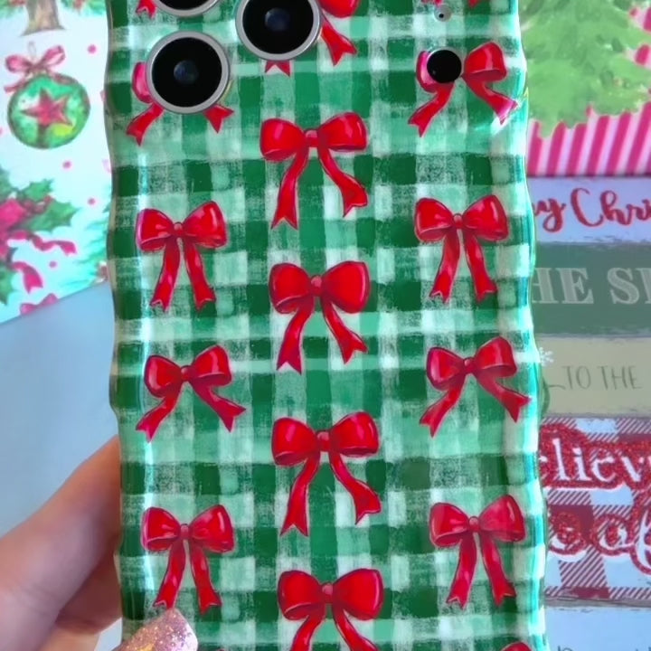Video: turning the Plaid Tidings & Bows Wavy Luxe iPhone case in hand to show the green gingham, red bows and glossy wavy edges