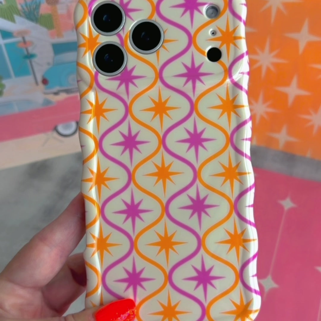 Trendy wavy iPhone case featuring a pink and orange starburst geometric pattern on a cream background with a high-gloss finish.