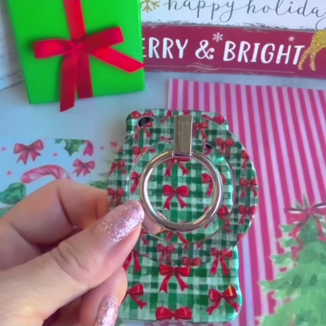 Video: Plaid Tidings & Bows grip ring shown close up, snapped onto the matching case and held with one finger through the silver ring