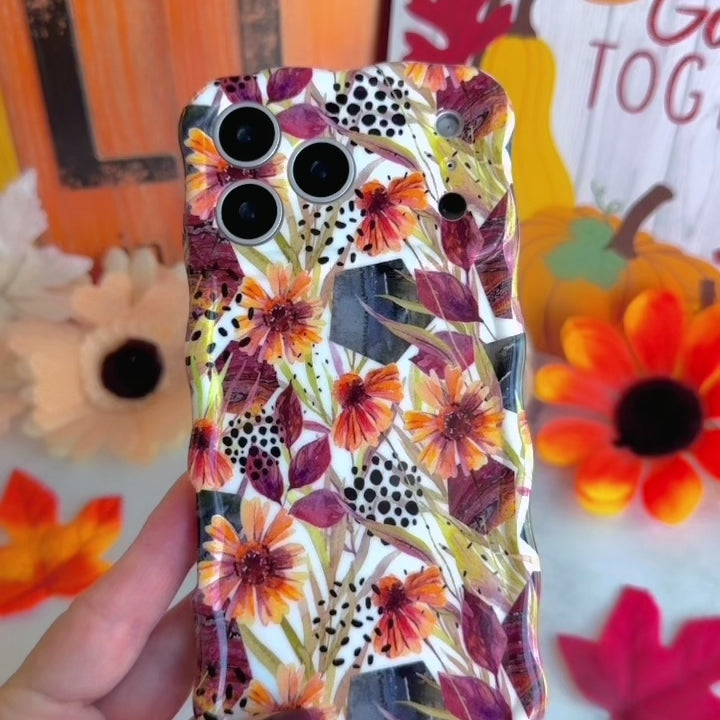 Video turning the Sienna Petals Wavy Luxe MagSafe iPhone case in hand, showing the cream watercolor floral print, black dot accents and glossy wavy edges.