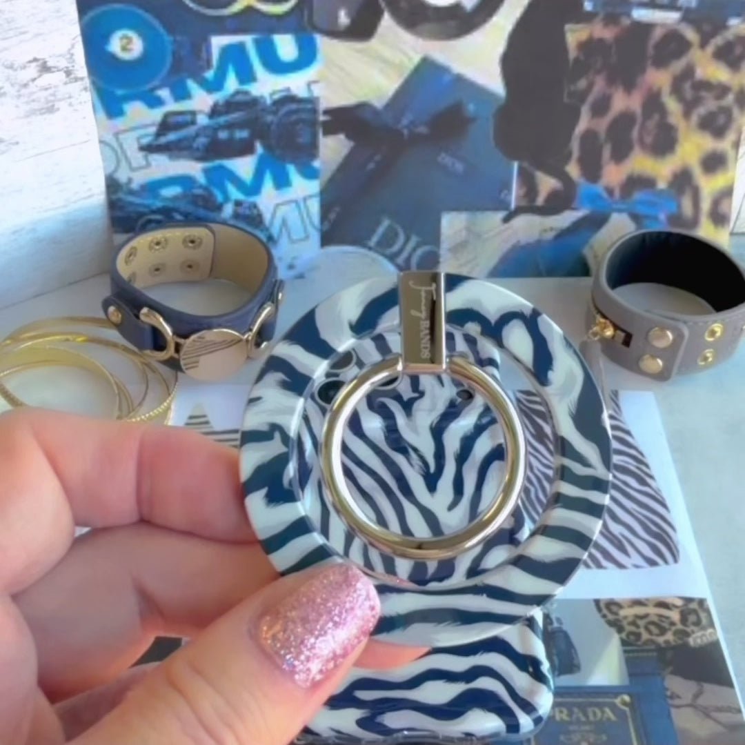 Video of a hand folding out the Zebra, Obviously navy zebra print MagSafe grip ring on the back of an iPhone and rotating the silver ring to use it as a finger grip.