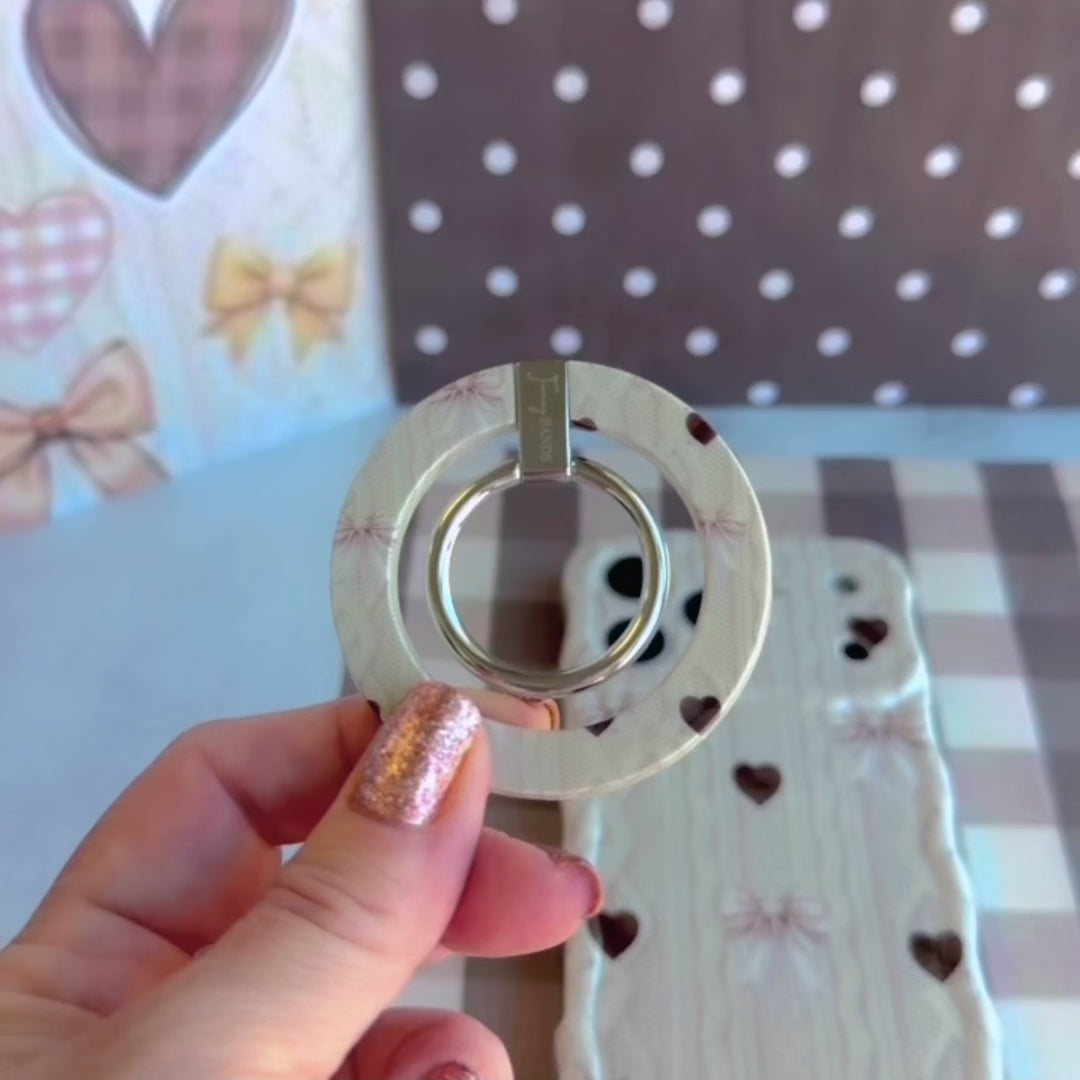 Video demonstration of the Sweater Weather Sweetheart Hold It Fancy MagSafe grip ring showing the 180-degree rotating ring and kickstand function with the cozy knit print.