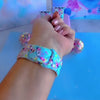 Video: Twinkle All The Way Apple Watch band worn on the wrist, then both Christmas lights straps shown on a pink jewelry box