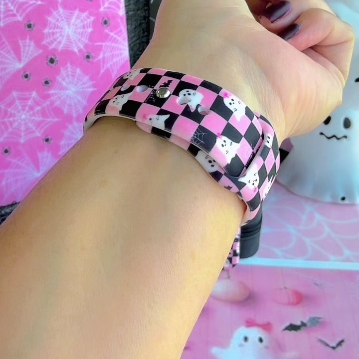 Video of the Hey Boo, Looking Cute silicone Samsung Galaxy Watch band worn on the wrist and shown in both sizes, pink and black checkerboard with white ghosts.