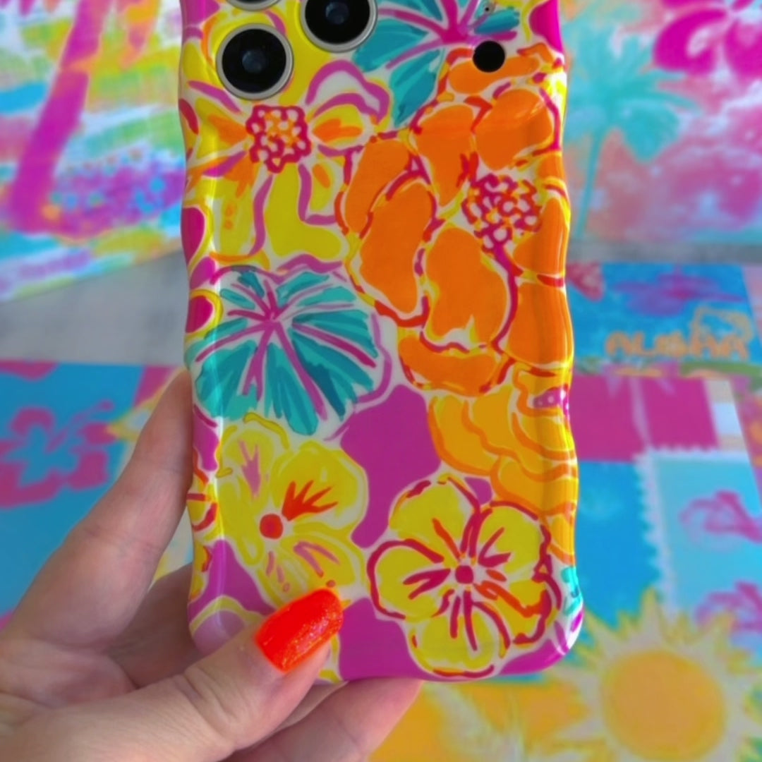 Trendy wavy iPhone case featuring a vibrant pink, orange, and teal hibiscus flower pattern with a high-gloss finish.