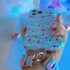 Video: Twinkle All The Way scrunchie wrist strap worn on the wrist with the matching iPhone case hanging from the clasp