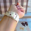 Video showing the Sweater Weather Sweetheart silicone Samsung Galaxy Watch band from multiple angles, featuring the cream cable-knit print with taupe bows and brown hearts.