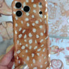 Warm whiskey-brown wavy iPhone case featuring a white fawn-spotted pattern with a high-gloss finish.