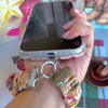 Video: Boot Scootin' Christmas scrunchie wrist strap worn on the wrist with the matching iPhone case hanging from the clasp