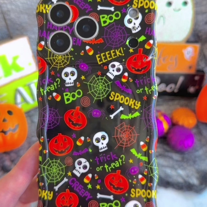 Video of the Spooky Wavy Luxe MagSafe iPhone case turning in hand to show the black pumpkin and skull print and the sculpted wavy edge.