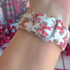 Video: Deck Yourself in Bows & Holly Apple Watch band worn on the wrist, then both bow-print straps shown on a black jewelry box