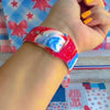 Sweet Freedom 250 silicone Apple Watch band celebrating America's 250th anniversary with "250 Years 1776" emblem, American flag, fireworks, red bow, and red, white, and blue tie-dye swirl with star sparkle, shown displayed and worn on Apple Watch against a patriotic 4th of July backdrop.