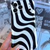 Wavy iPhone case featuring a bold black and white swirly striped pattern with a high-gloss finish.