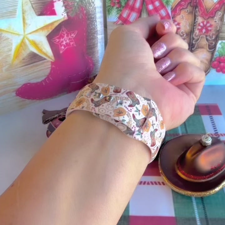 Video: Boot Scootin' Christmas Apple Watch band worn on the wrist, then both cowboy boot straps shown on a black jewelry box