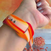Orange Crush Apple Watch band with vibrant gradient stripes in orange and coral tones with decorative mandala
