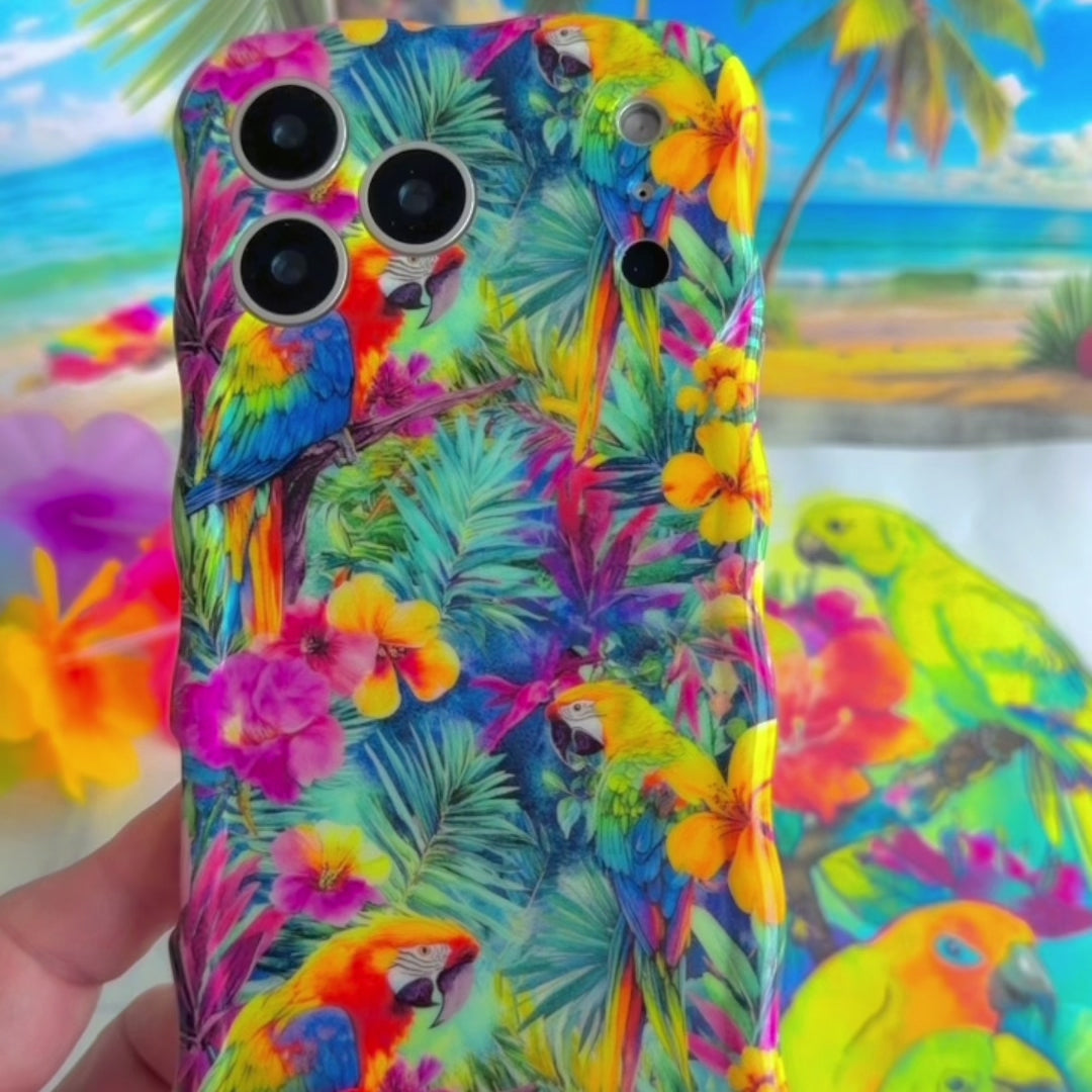 Trendy wavy iPhone case featuring a vibrant tropical pattern of red macaws, pink hibiscus, and green palm leaves with a high-gloss finish.