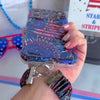 Video of the USA Fireworks Scrunchie Phone Wrist Strap worn on the wrist and clipped to the matching firework print phone case, showing the gathered fabric and silver clasp.
