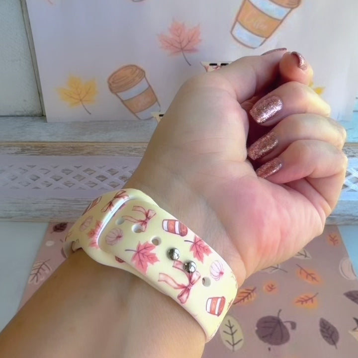 Video of the Falling in Love a Latte silicone Apple Watch band worn on the wrist and shown in both sizes, cream with coffee cups, maple leaves and bows.