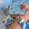 Video: Snow Pretty In Blue scrunchie wrist strap worn on the wrist with the matching iPhone case hanging from the clasp