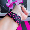 Sweet Spot Apple Watch band with pink polka dots and bow accents on black background with striped backdrop
