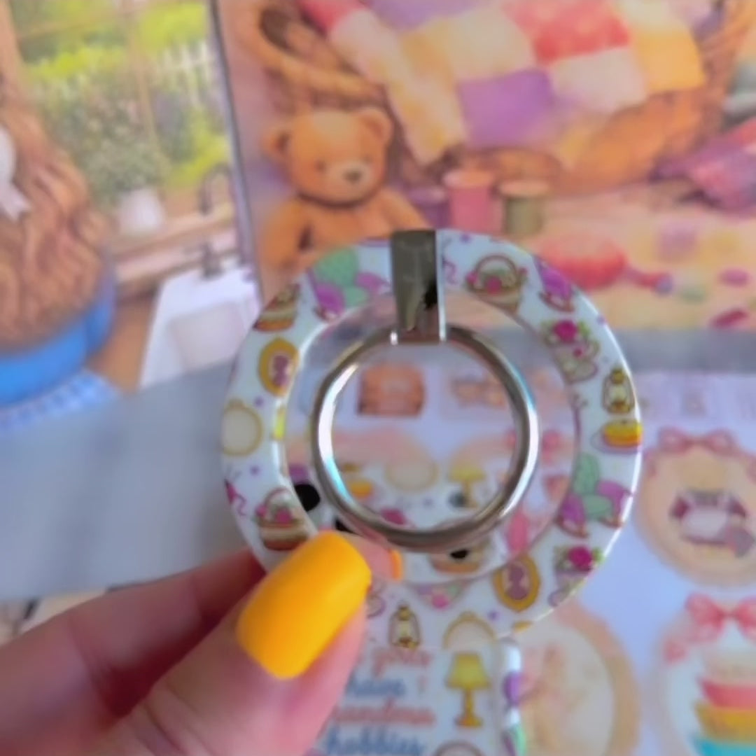 It's Giving Grandma Hobbies cozy grandmacore MagSafe phone grip ring with knitting yarn, rocking chairs, teacups, and pies on a white background compatible with iPhone and Samsung