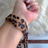 Rawr Mode Apple Watch band with bold tan and black leopard print pattern on white fur background
