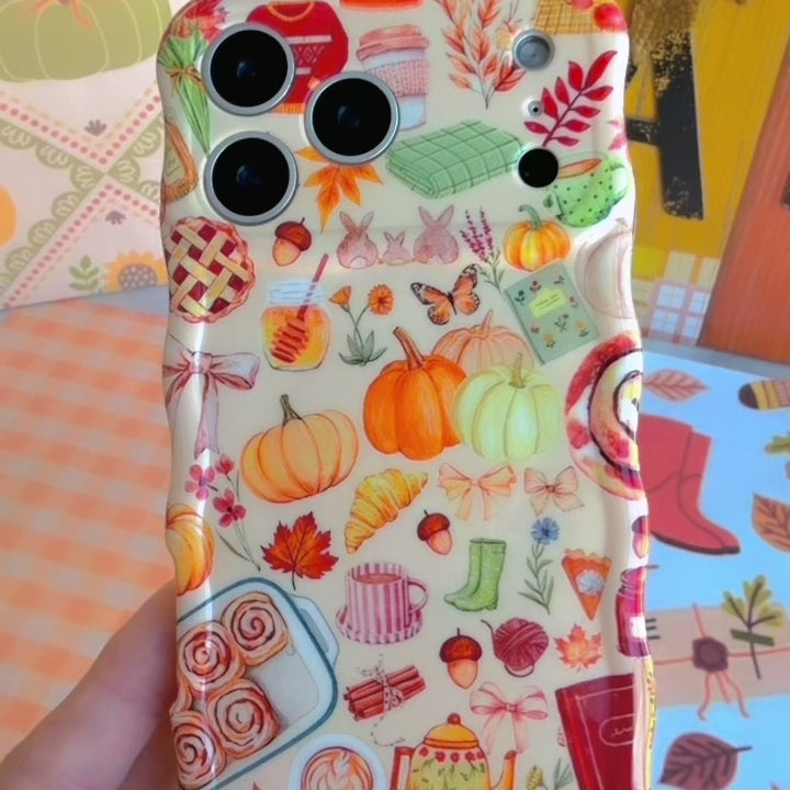 Video of the All The Fall Things Wavy Luxe MagSafe iPhone case showing the glossy cream finish and its watercolor pumpkin, pie and autumn leaf collage from every angle.