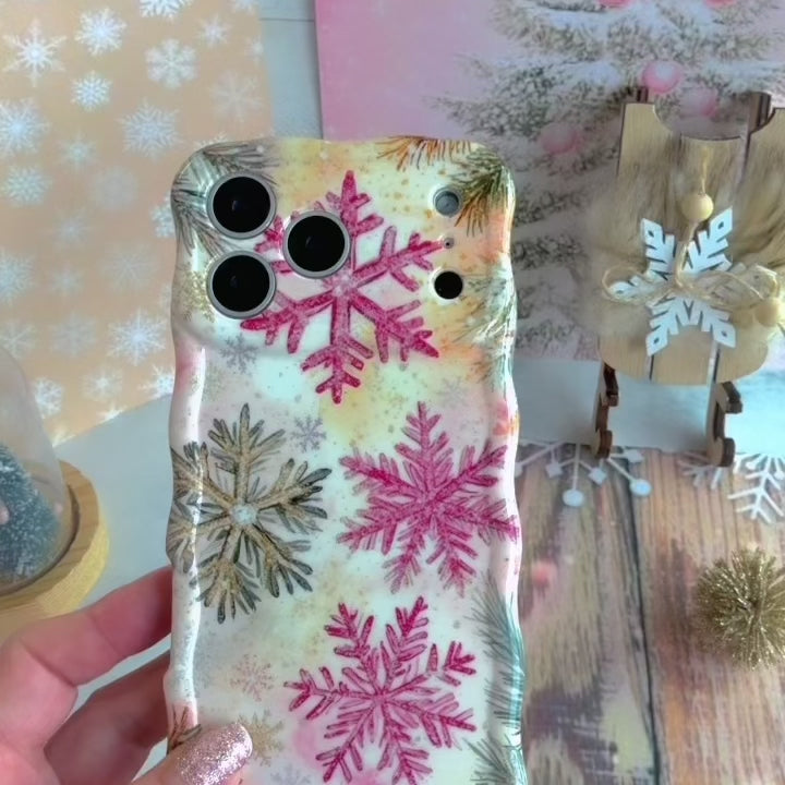 Video: turning the Champagne Snowfall Wavy Luxe iPhone case in hand to show the pink and gold snowflake print and glossy wavy edges