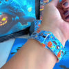 Video of The Bewitching Hour silicone Apple Watch band worn on the wrist and shown in both sizes, light blue with jack-o-lanterns, witch hats and owls.