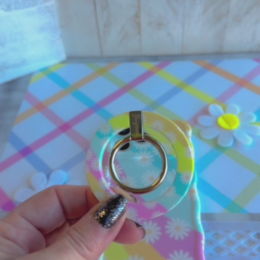 Daisy Dream MagSafe grip ring with pastel rainbow waves and white daisies on phone