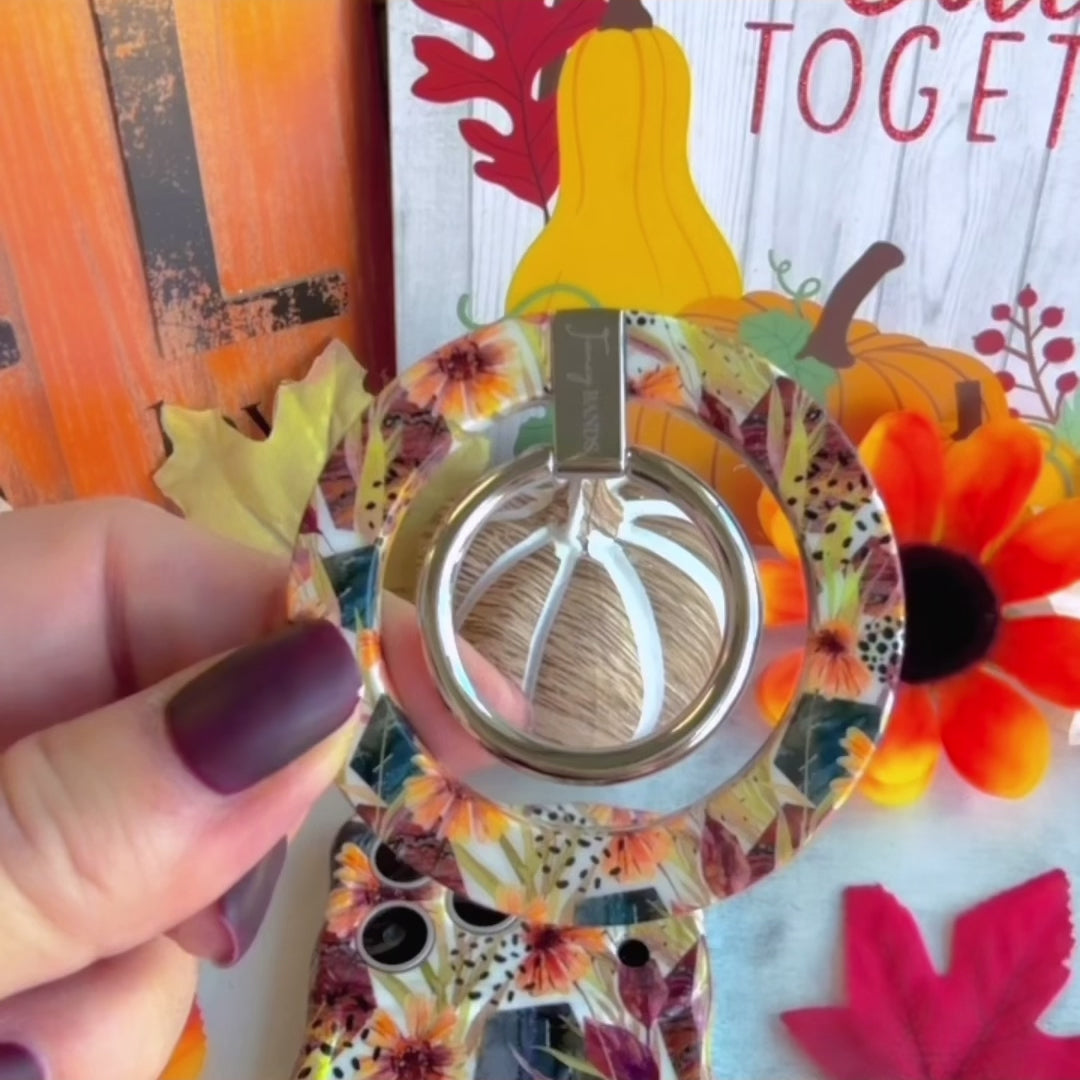 Video of the Sienna Petals MagSafe grip ring on the back of the matching cream floral case, rotating the metal ring and hooking a finger through it.