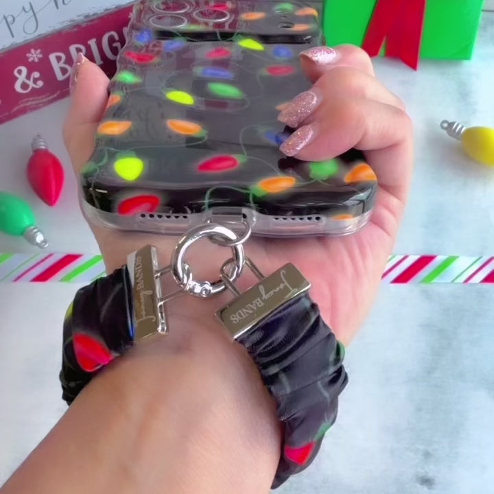 Video: Christmas Lights scrunchie wrist strap worn on the wrist with the matching black string-lights iPhone case hanging from the clasp