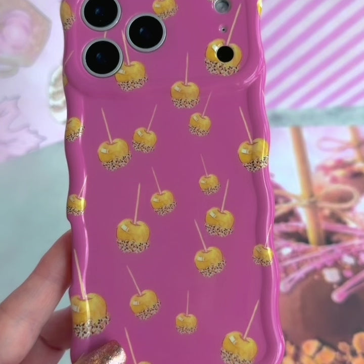 Video of the Caramel Coated Cutie Wavy Luxe MagSafe iPhone case showing the glossy rose-pink finish and golden caramel apple print from every angle.