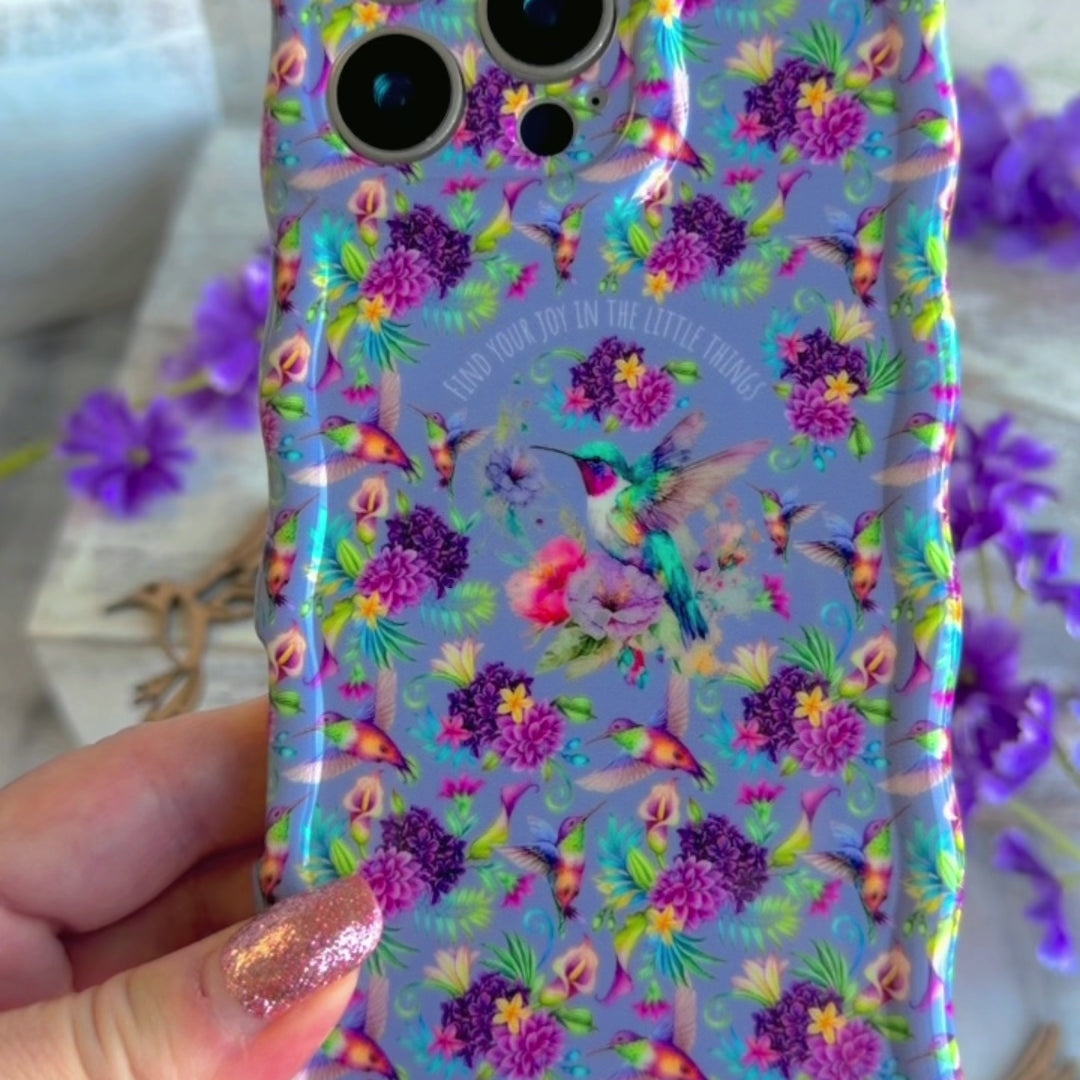 Lavender wavy iPhone case featuring colorful hummingbirds, purple flowers, and the quote Find Your Joy In The Little Things.