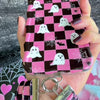 Video of the Hey Boo, Looking Cute Scrunchie Phone Wrist Strap being clipped to a phone case and worn on the wrist, showing the gathered pink checkerboard fabric and metal clasp.