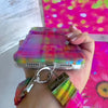 Video of the Hazy Tartan Scrunchie Phone Wrist Strap worn on the wrist and clipped to the matching blurred plaid phone case, showing the gathered fabric and silver clasp.