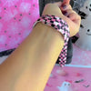 Video of the Hey Boo, Looking Cute silicone Apple Watch band worn on the wrist and shown in both sizes, pink and black checkerboard with white ghosts.