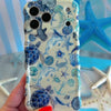 Trendy white wavy iPhone case featuring a blue monochrome collage of sea turtles, whales, dolphins, and starfish with a high-gloss finish.