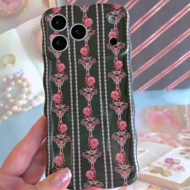 Video turning the Pretty Little Details Wavy Luxe MagSafe iPhone case in hand to show the pearl strands, rose gold filigree and blush roses over the glossy wavy edges.
