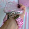 Video of the Blush Manor Scrunchie Phone Wrist Strap worn on the wrist and clipped to the matching pink toile case, showing the gathered fabric and silver clasp.