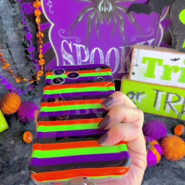 Video of the Main Witch Energy scrunchie phone wrist strap clipped to the matching striped case and worn on the wrist.