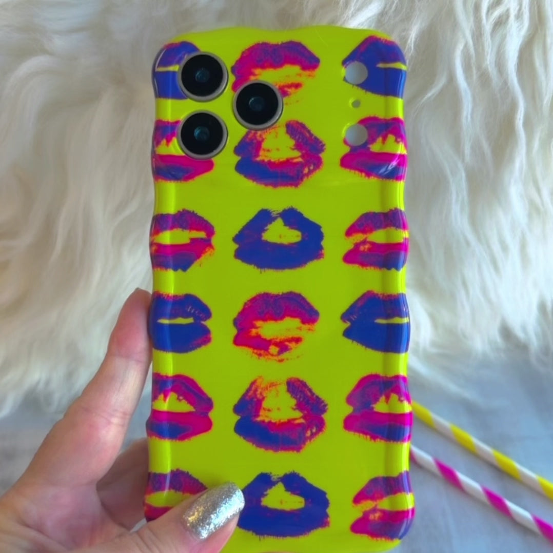 Neon yellow wavy iPhone case featuring a pattern of blue, pink, and red kiss lips in a pop-art style.