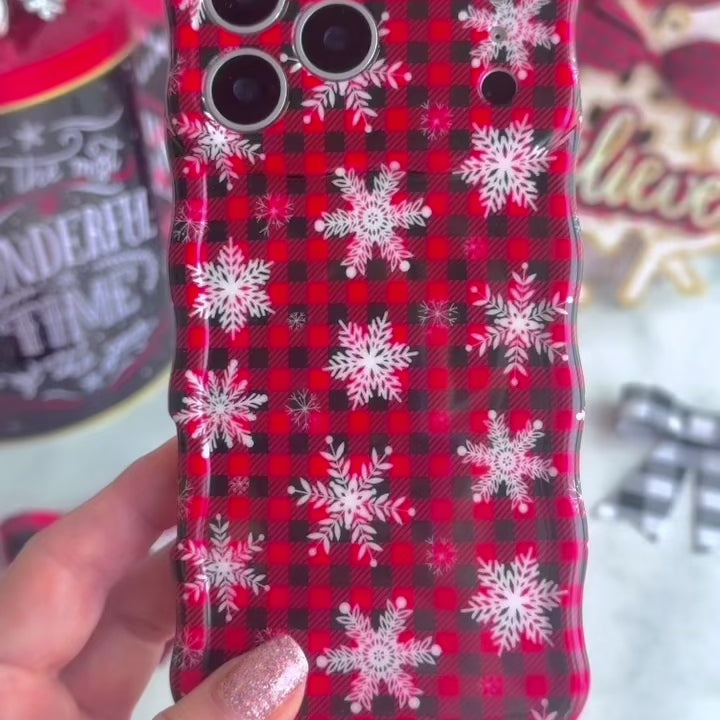 Video: close-up of the Buffalo Plaid Snowflake Wavy Luxe MagSafe iPhone case in hand showing the glossy red and black buffalo plaid with white snowflakes and wavy edges