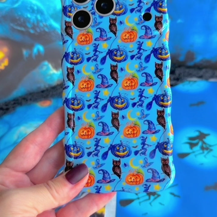 Video turning The Bewitching Hour Wavy Luxe MagSafe iPhone case in hand, showing the light blue witch hat, owl and jack-o-lantern print and the sculpted wavy edges.