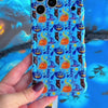 Video turning The Bewitching Hour Wavy Luxe MagSafe iPhone case in hand, showing the light blue witch hat, owl and jack-o-lantern print and the sculpted wavy edges.