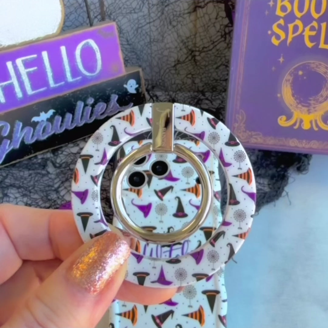 Video demo of the Witch Please MagSafe grip ring snapping onto the matching cream witch hat case, then used as a finger hold and kickstand.